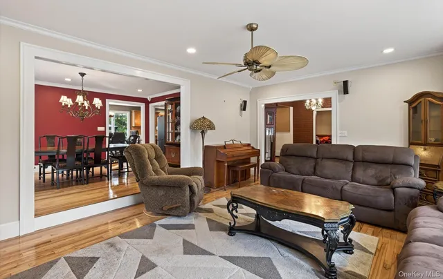 a living room with furniture a chandelier and a large window