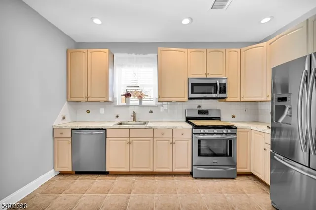 a kitchen with stainless steel appliances a stove sink microwave and refrigerator