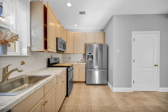 a kitchen with a sink a refrigerator and cabinets