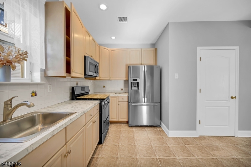 48 Main Avenue Wallington, NJ 07057 - Photo 14 of 50 a kitchen with a sink a refrigerator and cabinets