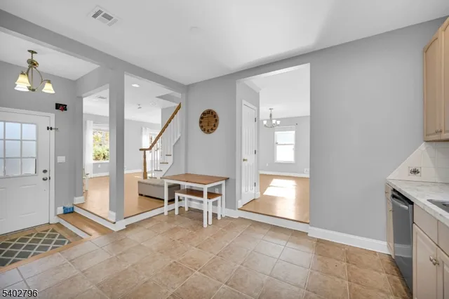 a view of an empty room and a kitchen