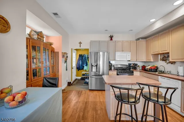 a kitchen with stainless steel appliances wooden floor dining table and chairs