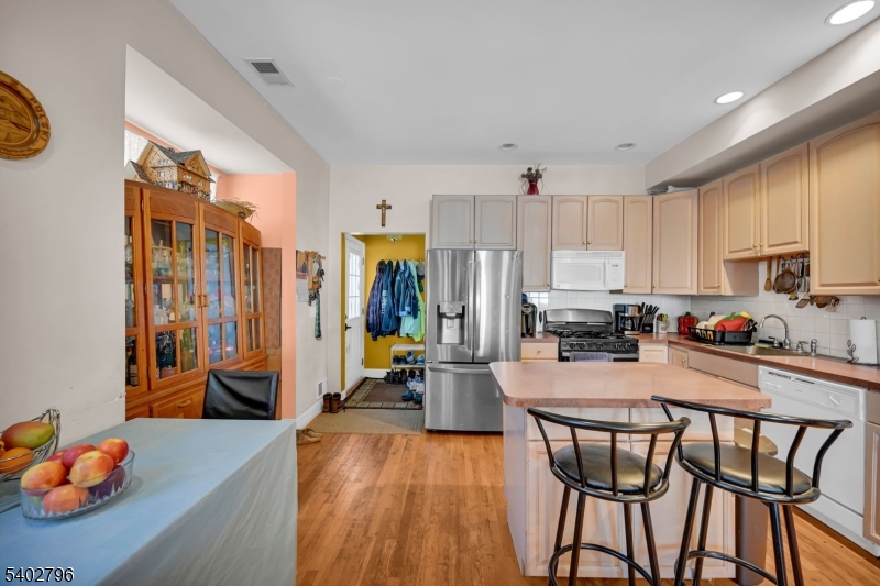 48 Main Avenue Wallington, NJ 07057 - Photo 27 of 50 a kitchen with stainless steel appliances wooden floor dining table and chairs