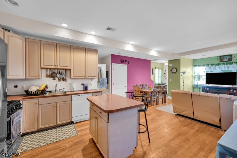48 Main Avenue Wallington, NJ 07057 - Photo 28 of 50 a kitchen with stainless steel appliances granite countertop a stove top oven a sink dishwasher a dining table and chairs with wooden floor