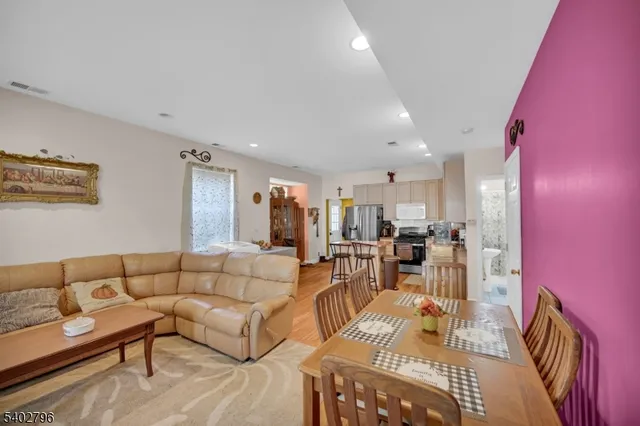 a living room with furniture and a dining table with rug