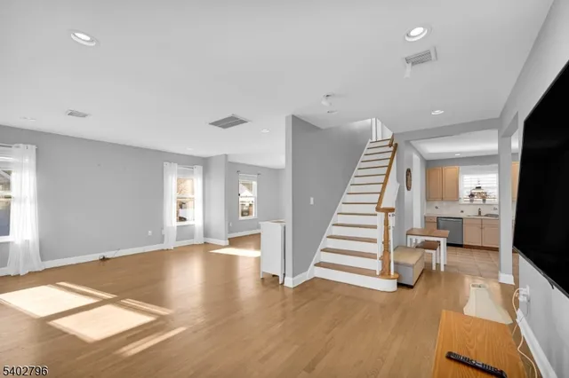a view of a livingroom with wooden floor and stairs