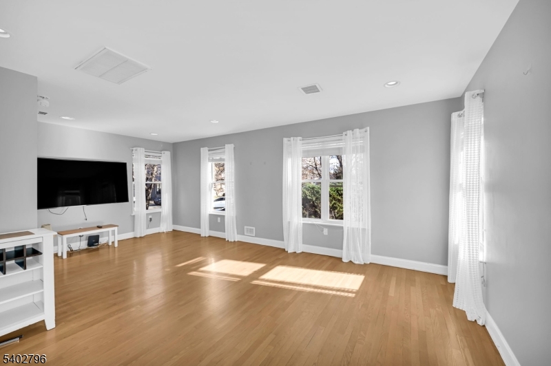 48 Main Avenue Wallington, NJ 07057 - Photo 9 of 50 a view of a livingroom with wooden floor and a flat screen tv