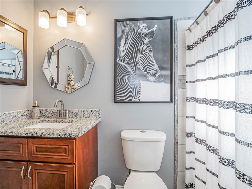 438 Columbus Street Sebastian, FL 32958 - Photo 13 of 32 a bathroom with a granite countertop toilet sink and mirror