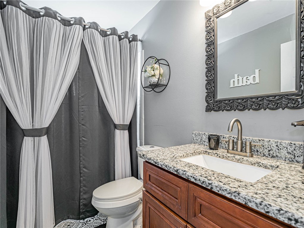 438 Columbus Street Sebastian, FL 32958 - Photo 15 of 32 a bathroom with a granite countertop sink a toilet and a mirror