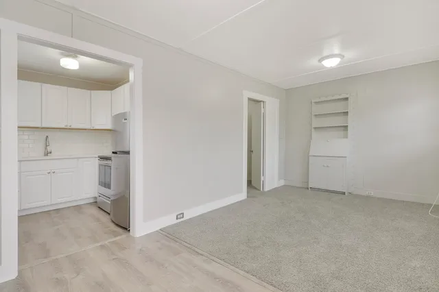 a view of a kitchen with white cabinets and a refrigerator