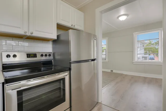 a kitchen with stainless steel appliances wooden floor sink and wooden cabinets