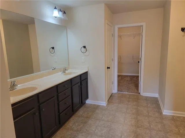 a bathroom with a double vanity sink a large mirror and a shower
