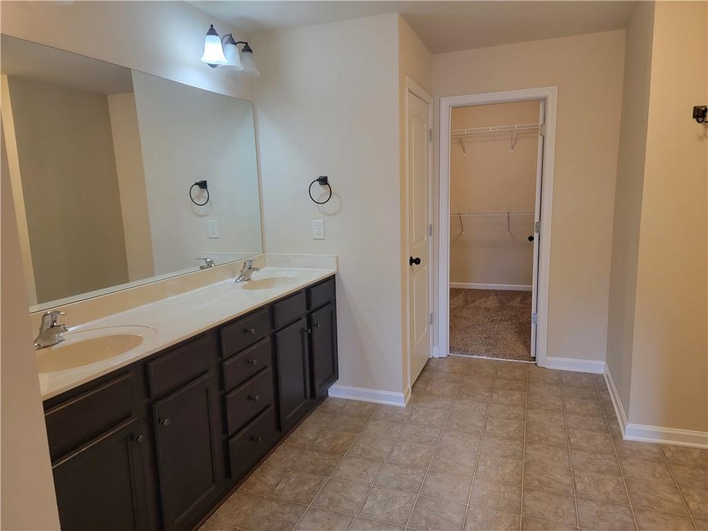 2707 Morgan Glen Road Northeast Buford, GA 30519 - Photo 16 of 24 a bathroom with a double vanity sink a large mirror and a shower