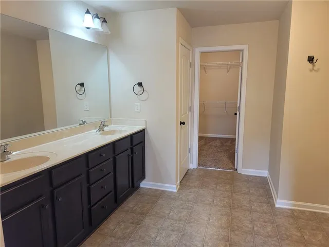a spacious bathroom with a double vanity sink mirror and shower