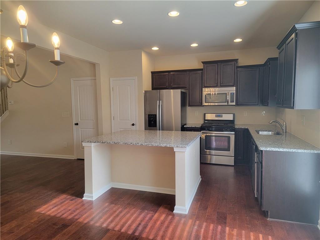 2707 Morgan Glen Road Northeast Buford, GA 30519 - Photo 2 of 24 a kitchen with kitchen island a counter top space a sink stainless steel appliances and cabinets