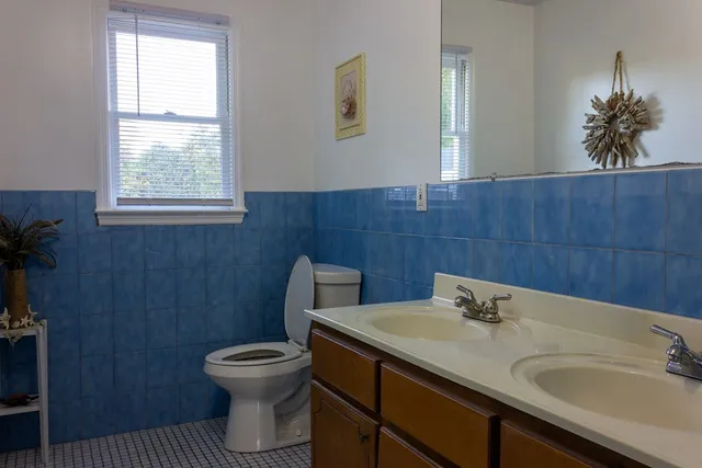 a bathroom with a toilet a sink and mirror