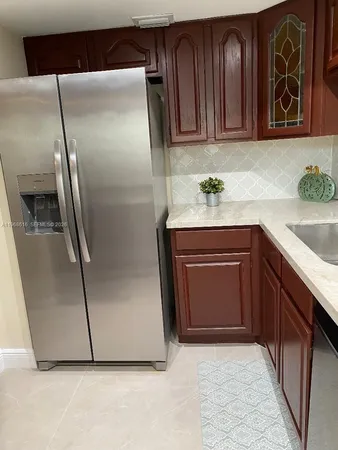 a kitchen with granite countertop a refrigerator and a sink
