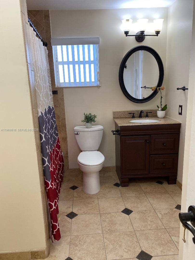 11339 Southwest 71st Lane Miami, FL 33173 - Photo 16 of 19 a bathroom with a toilet a sink and a mirror