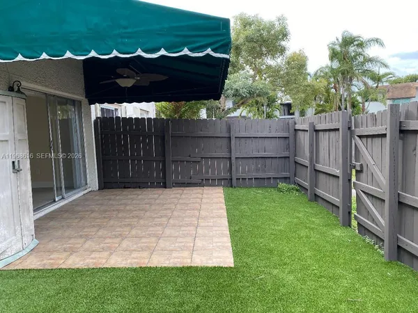 a view of a backyard with a small cabin and wooden fencing