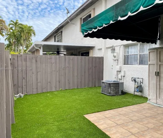 a backyard of a house with table and chairs