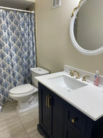 a bathroom with a toilet a sink and mirror