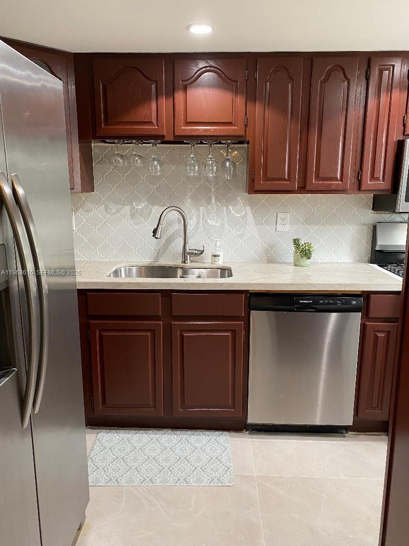 11339 Southwest 71st Lane Miami, FL 33173 - Photo 9 of 19 a kitchen with stainless steel appliances granite countertop a sink a stove a refrigerator and cabinets