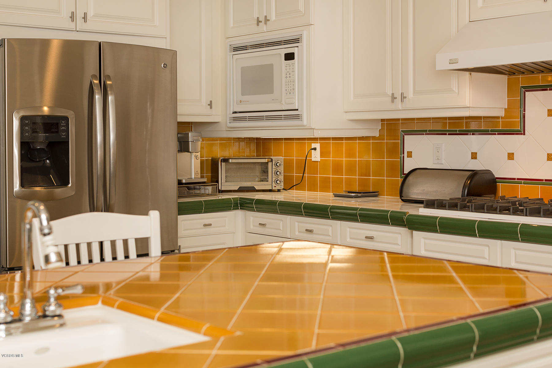 558 Rustic Hills Drive Simi Valley, CA 93065 - Photo 19 of 50 a kitchen with stainless steel appliances a stove a sink and white cabinets