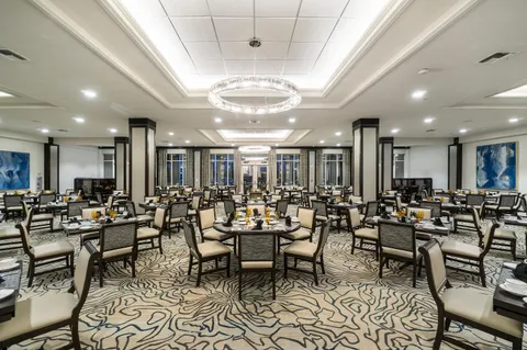 a large hall with lots of chairs a large window and a clock