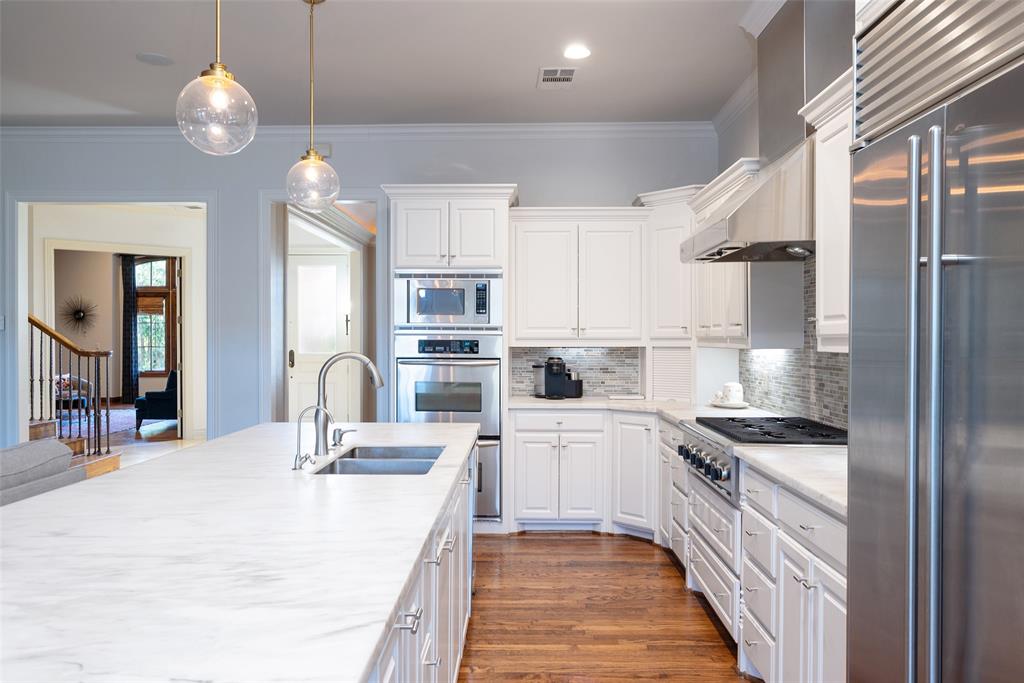 4422 Pomona Road Dallas, TX 75209 - Photo 5 of 34 a kitchen with white cabinets and stainless steel appliances