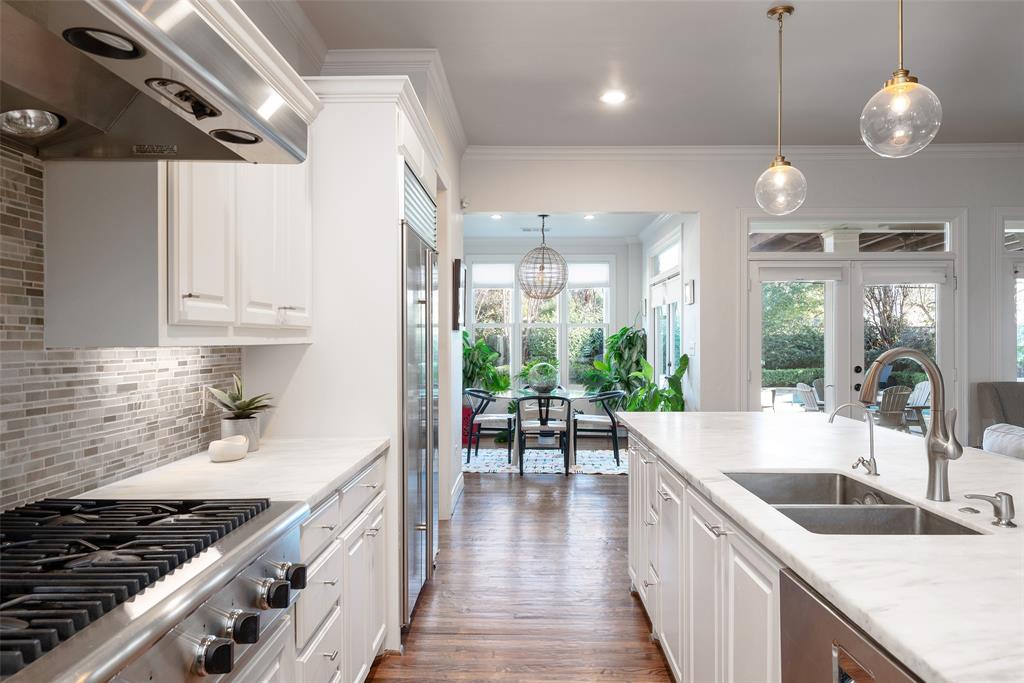 4422 Pomona Road Dallas, TX 75209 - Photo 6 of 34 a kitchen with stainless steel appliances granite countertop a sink a stove and a wooden floors