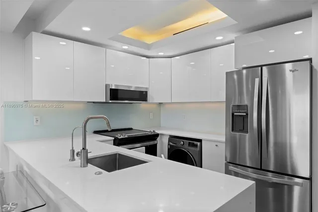 a kitchen with stainless steel appliances a refrigerator sink and microwave