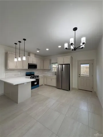 a large kitchen with kitchen island a sink stainless steel appliances and cabinets