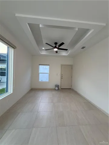 an empty room with windows and ceiling fan