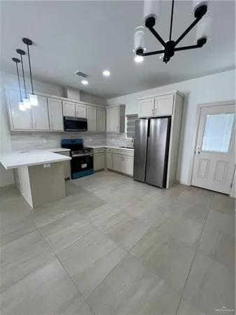 a view of kitchen with stainless steel appliances granite countertop a refrigerator oven a sink with dishwasher and white cabinets