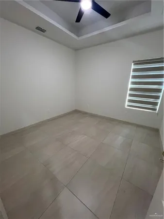 an empty room with a ceiling fan and window