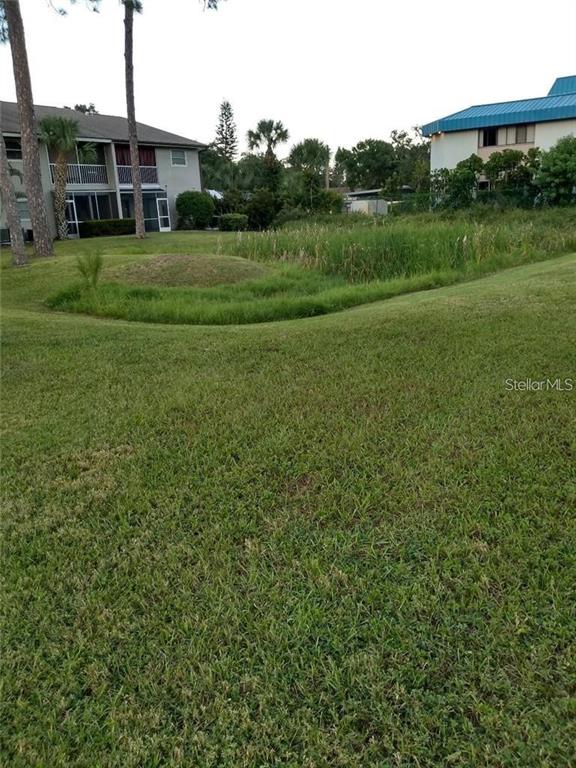 5787 Summerside Lane, Unit 4B Sarasota, FL 34231 - Photo 11 of 21 a view of a grassy field with trees