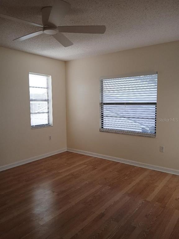 5787 Summerside Lane, Unit 4B Sarasota, FL 34231 - Photo 16 of 21 an empty room with wooden floor and windows