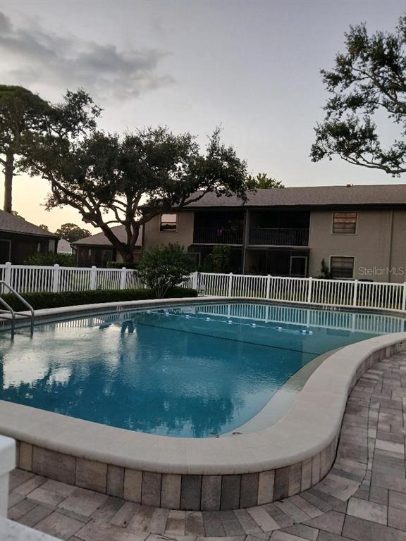 5787 Summerside Lane, Unit 4B Sarasota, FL 34231 - Photo 20 of 21 a view of a swimming pool with a lounge chair