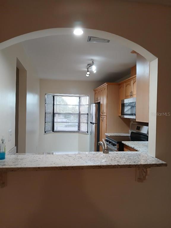 5787 Summerside Lane, Unit 4B Sarasota, FL 34231 - Photo 7 of 21 a view of kitchen island a sink wooden floor and living room view