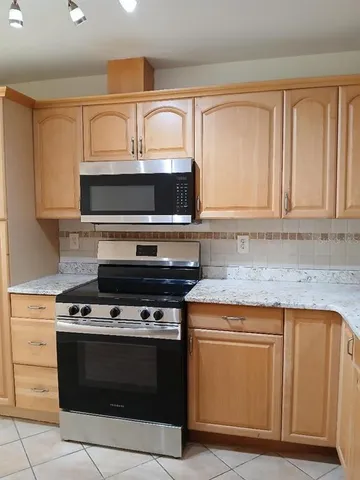 a stove top oven sitting inside of a kitchen