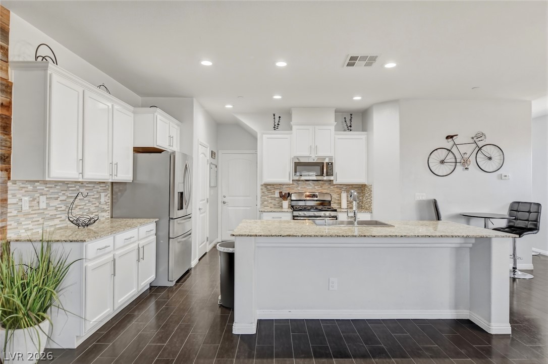 48 Jasmine Point Street Henderson, NV 89074 - Photo 20 of 62 A well-appointed kitchen features stainless steel appliances, granite countertops, and rich hardwood flooring throughout.