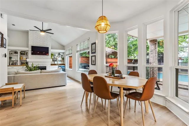 a view of a dining room with furniture a chandelier and wooden floor