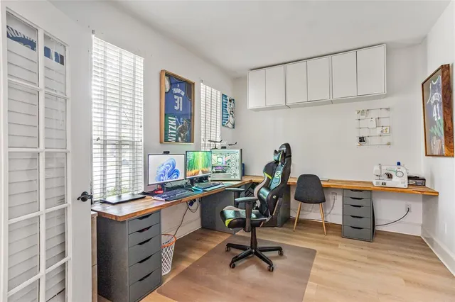 a view of a workspace with furniture and a window