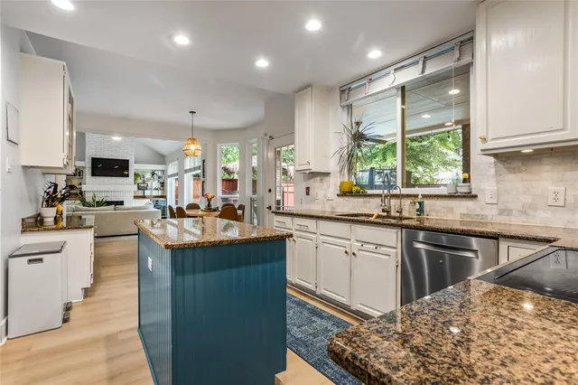a kitchen with stainless steel appliances kitchen island granite countertop a sink stove and refrigerator