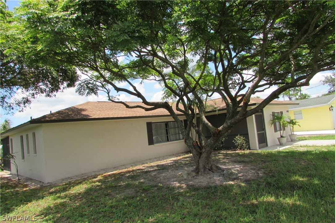 4983 18th Court Southwest Naples, FL 34116 - Photo 20 of 25 a view of a house with a tree and a yard