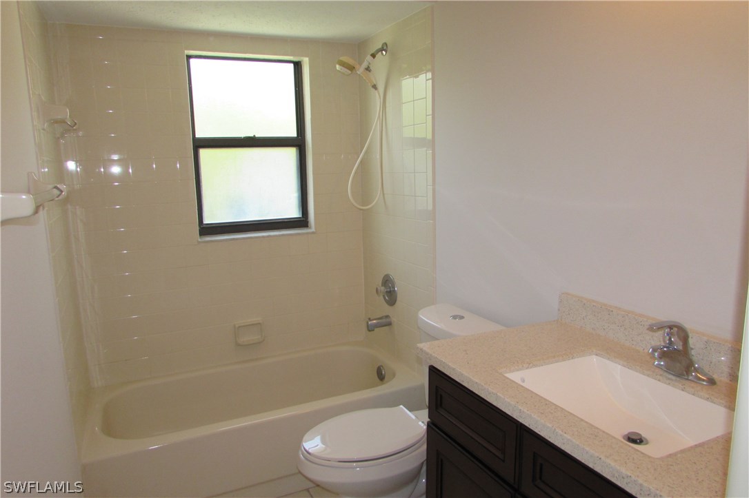 4983 18th Court Southwest Naples, FL 34116 - Photo 23 of 25 a bathroom with a bathtub shower sink vanity and toilet