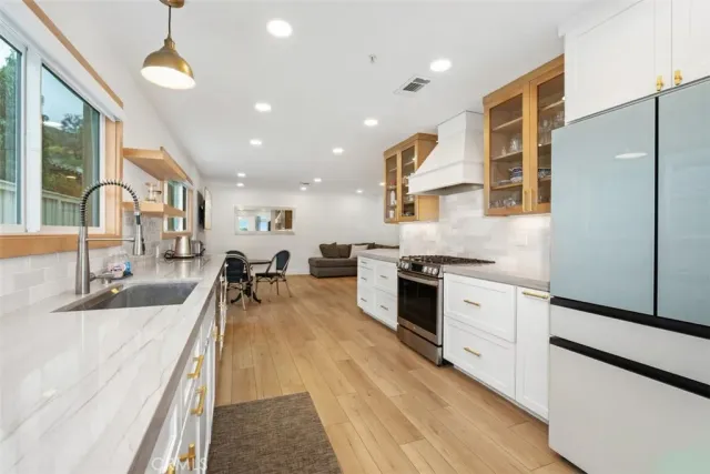 a large kitchen with stainless steel appliances kitchen island granite countertop a large counter top a stove and a sink