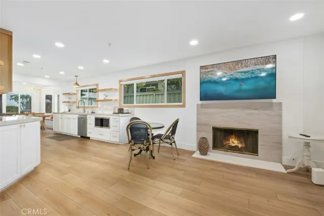 a living room with furniture a fireplace and kitchen view