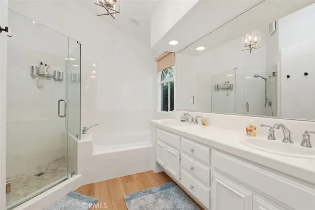 a bathroom with a tub sink shower and mirror