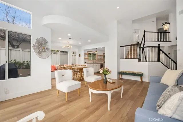 a living room with furniture a rug and kitchen view